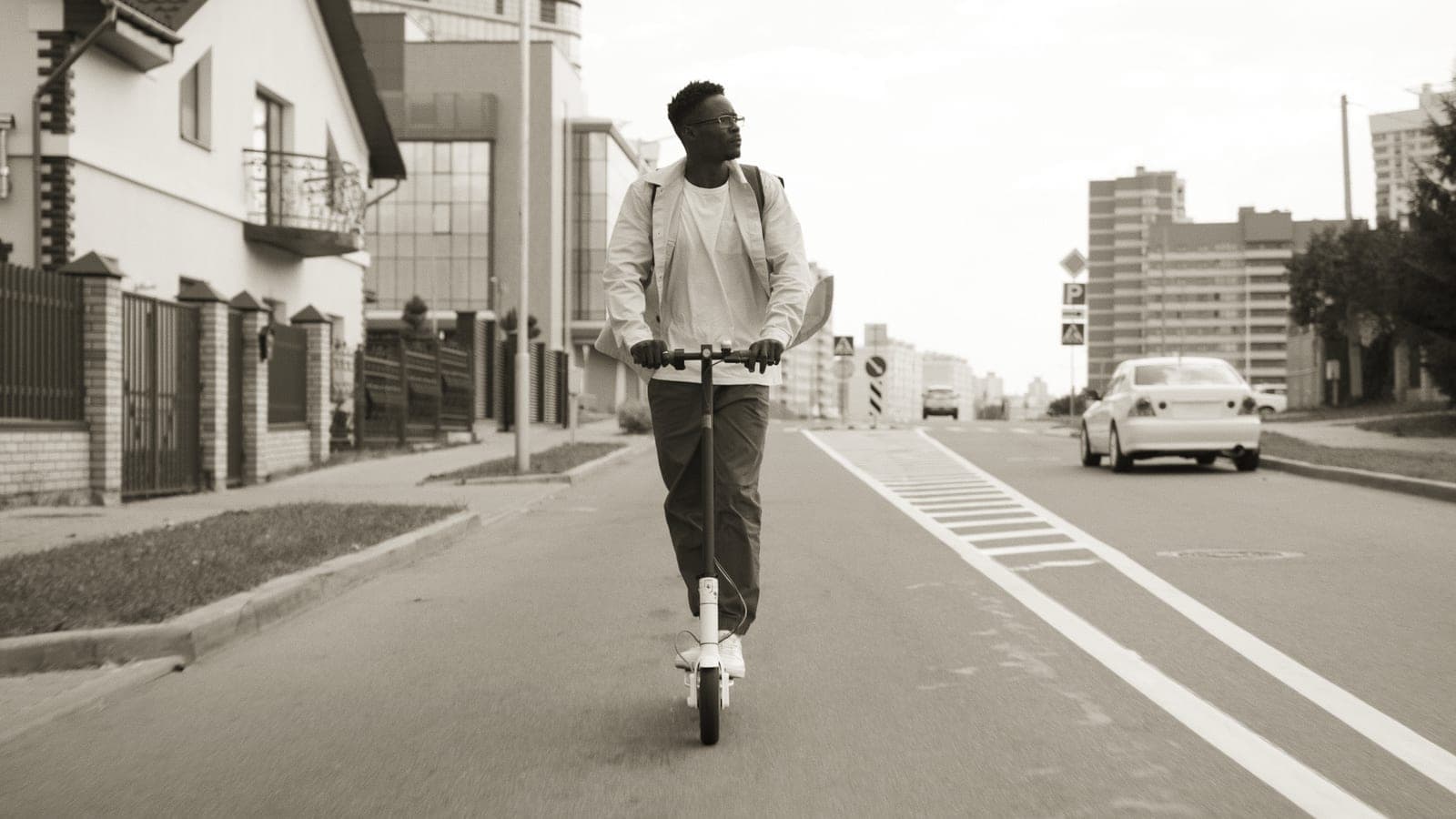 A rider on an electric scooter on a city street in the morning